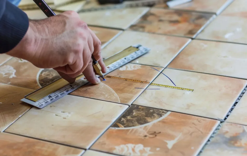 Artisan d’ERDEM Carrelage posant du carrelage de sol dans une maison à Pajay en Isère.